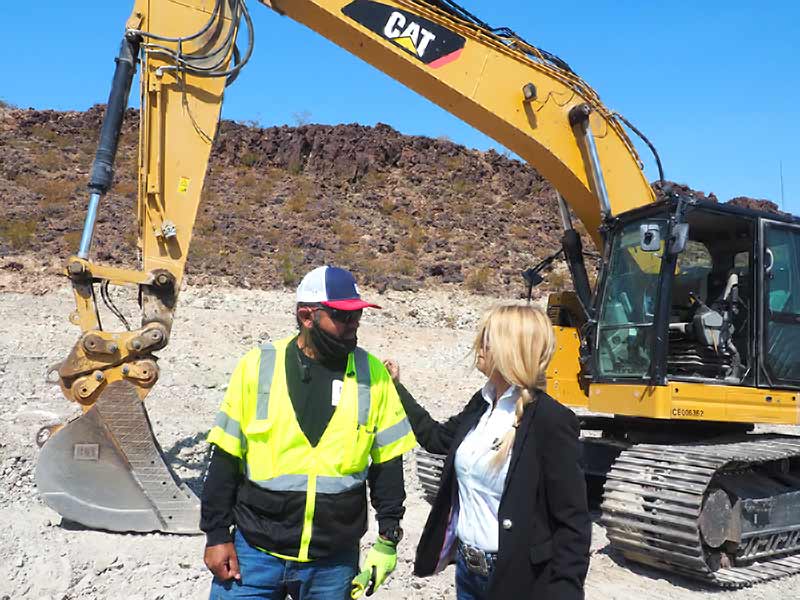 Two C and S staff beside an excavator bucket on site