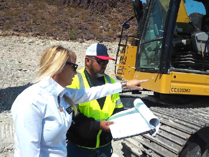 Two C and S staff going over the work beside an excavator