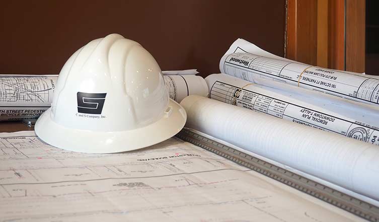 Hard hat resting on rolled plan sets